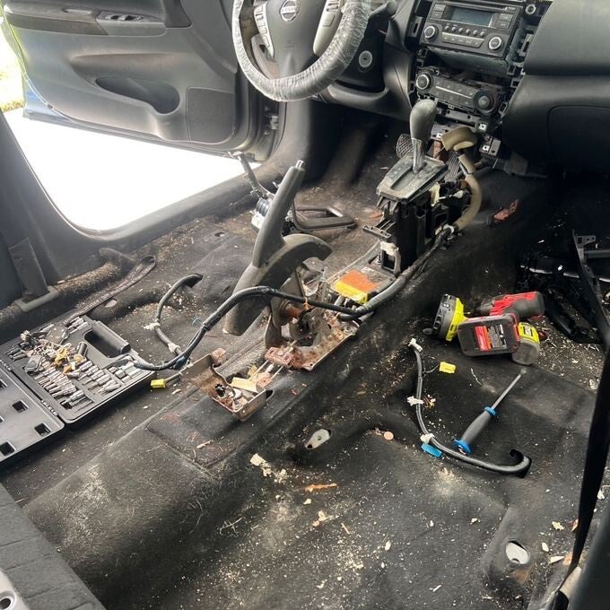 Nissan interior with seats and console removed exposing soiled carpet