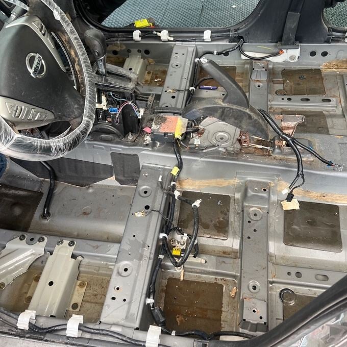 Nissan floor pan exposed after carpet removal during flood restoration