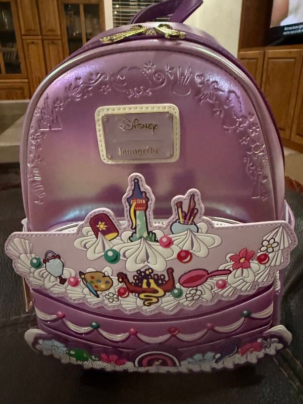 Loungefly Disney Tangled Cake Mini Backpack, which is a BoxLunch exclusive featuring an iridescent purple design with iconic Rapunzel elements.