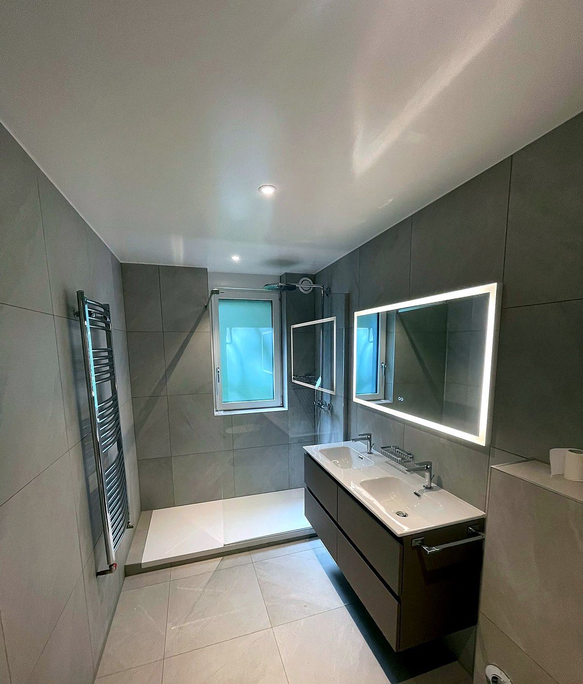 Lavabo suspendu et robinetterie noire posés par HydroTech Rénovation – salle de bain rénovée à Moudon