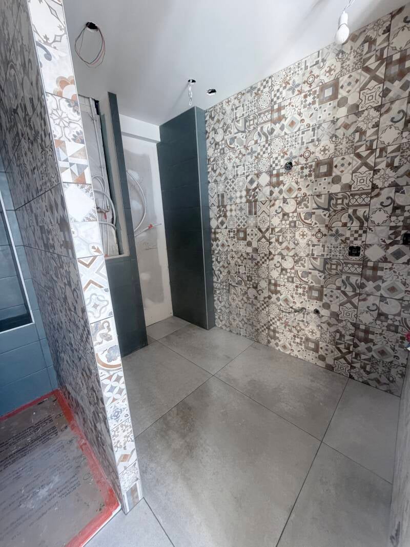 Salle de bain moderne avec carrelage bleu et mur décoratif. Pose de douche par Kocak Carrelage à Cognin/Chambéry.