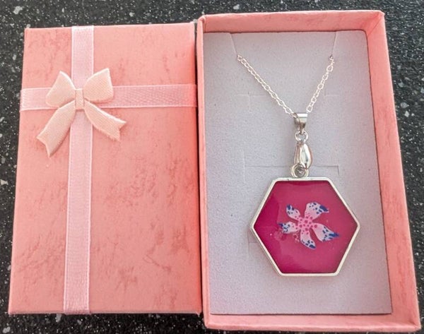 Hexagonal resin pendant with a flower charm