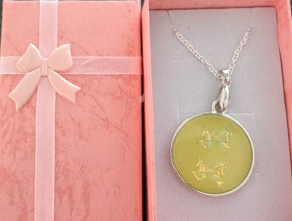 Round resin pendant with bow charms