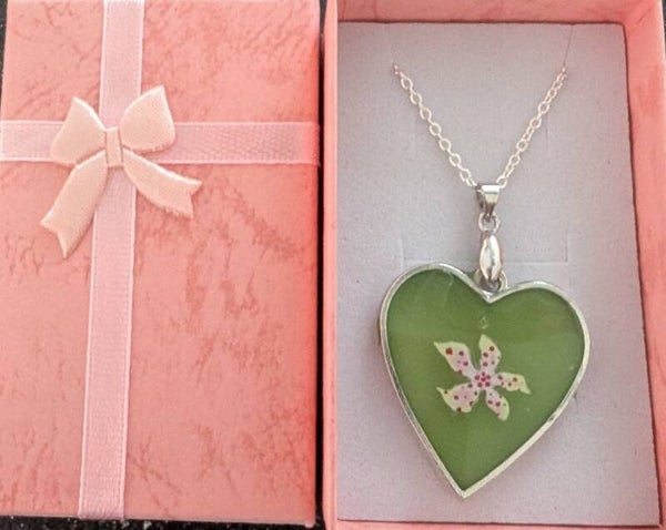 Heart shaped resin pendant with a flower charm