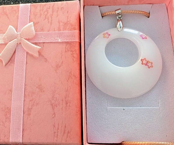 White round resin pendant with glitter stars on a rope necklace