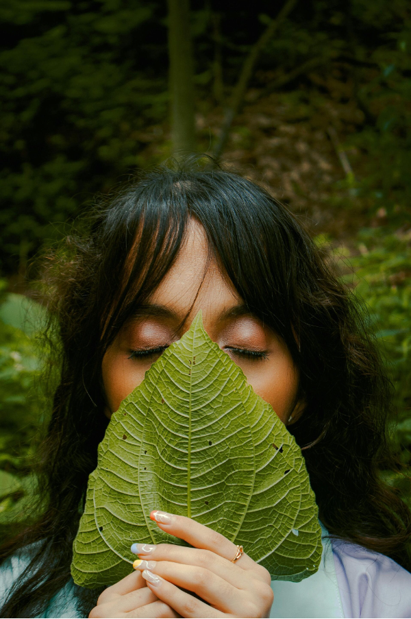 vrouw in de natuur met blad voor haar gezicht, symbool voor huidherstel en natuurlijke huidverzorging zonder schadelijke stoffen