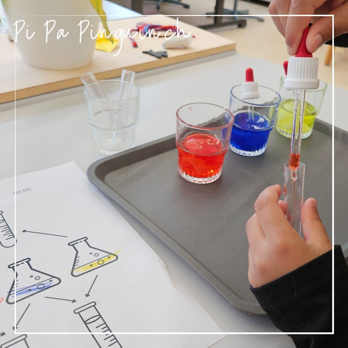 Kind mischt mit einer Pipette gefärbtes Wasser in einem Reagenzglas und dokumentiert das Farbenexperiment auf einem Laborblatt für Kinder.