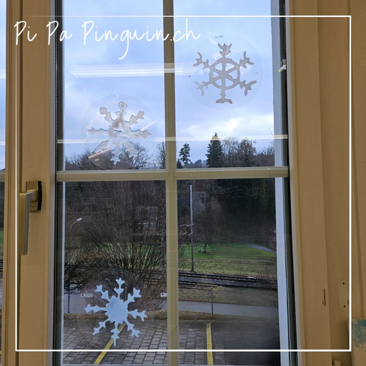 Mehrere Schneeflocken aus Leim als Fensterbilder im Schulzimmer im Winter