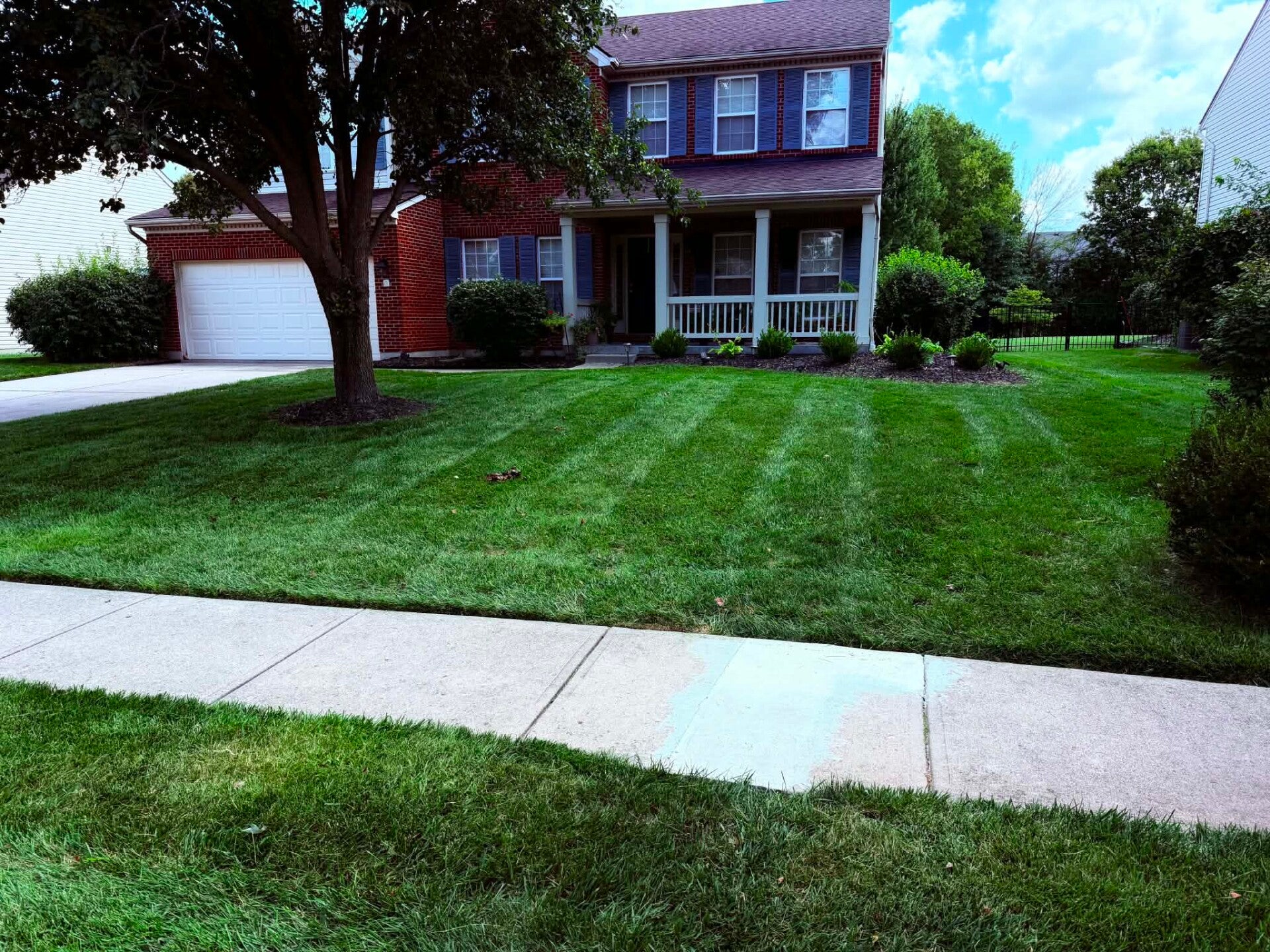 Professionally striped lawn and property maintenance by Nienaber And Sons Lawn Care at a residential home in Cleves, OH.⁠