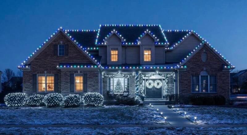 Professional Christmas light installation in Mason, Ohio, featuring classic blue and cool white C9 bulbs outlining the roofline and gables of a brick home.