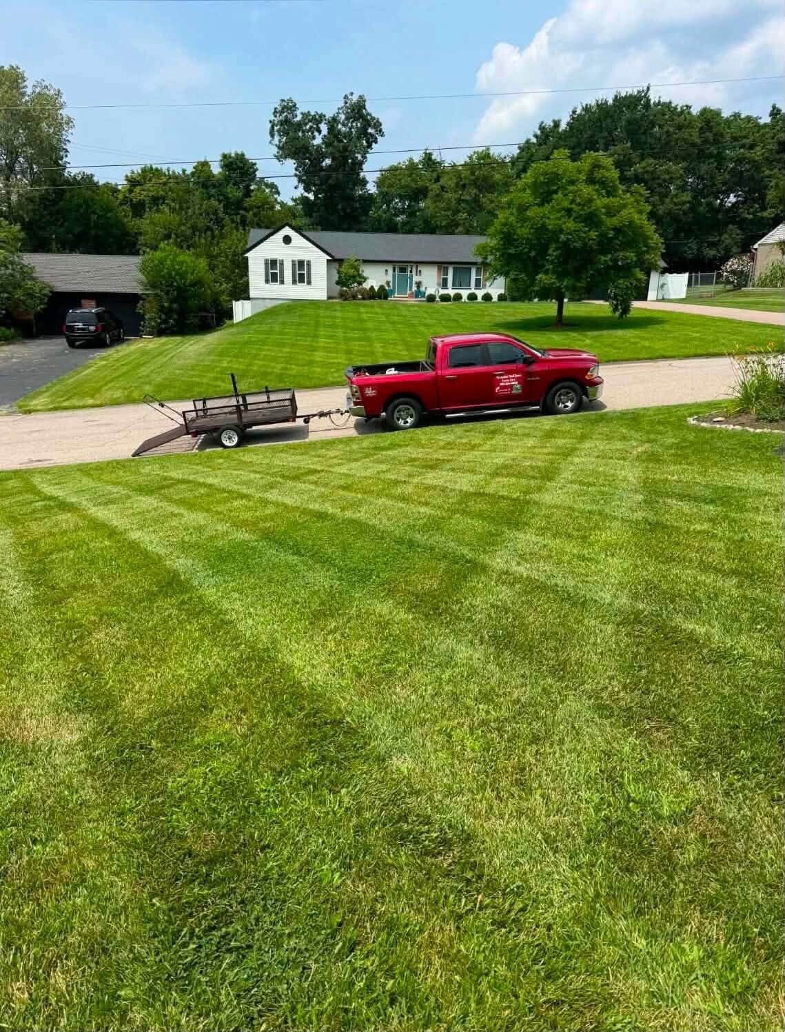 Crisp checkerboard lawn mowing stripes on a lush green front lawn in West Chester Township, OH