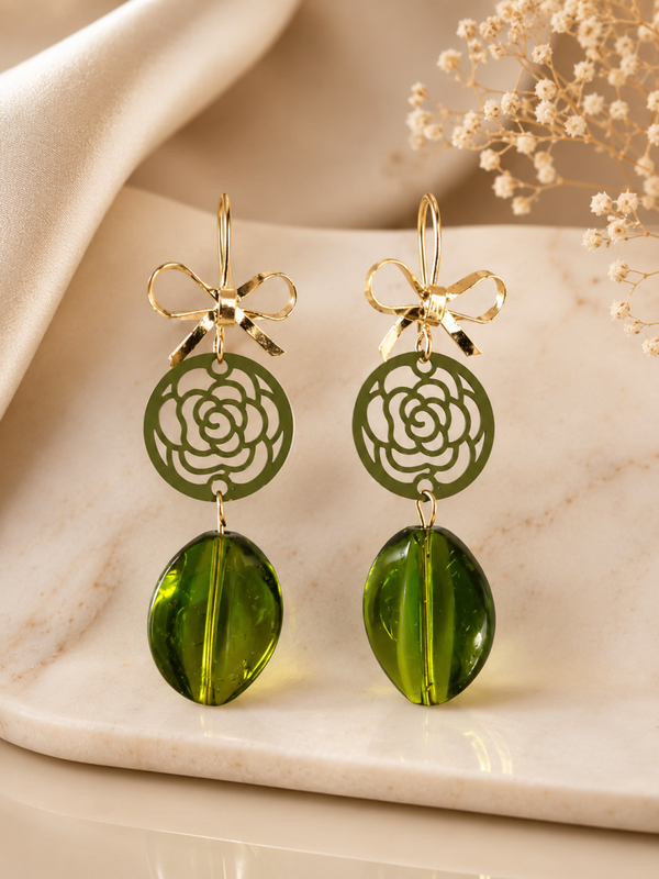 Groene statement oorbellen met strikdetail en bloemhanger