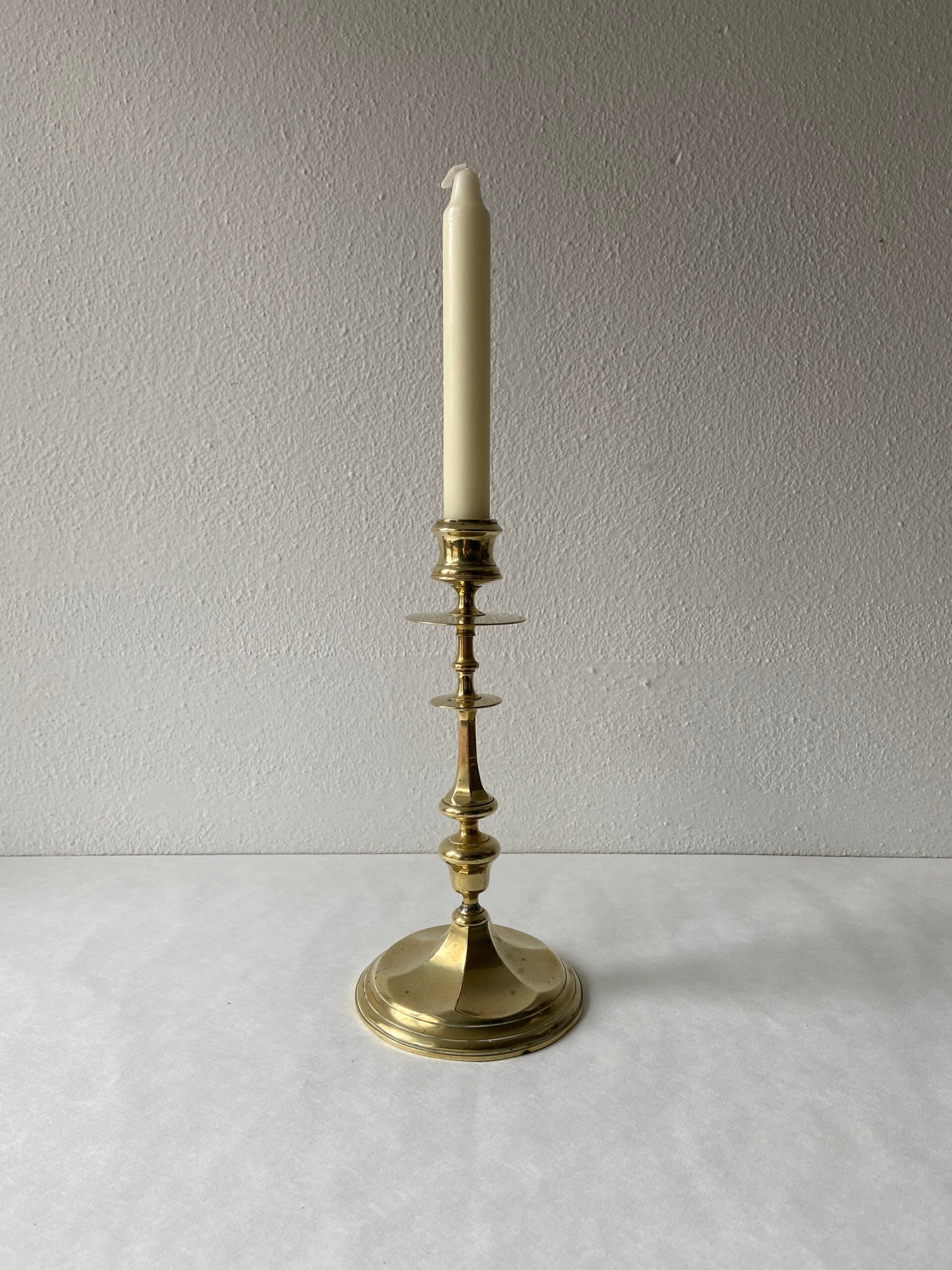 Hoge messing kandelaar met lekschaal en 6-kantige voet, iets scheef