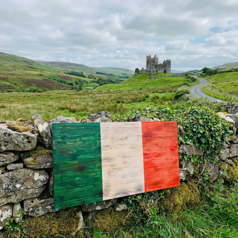 irish flat wood flag leaning against stone boundry in irish countryside