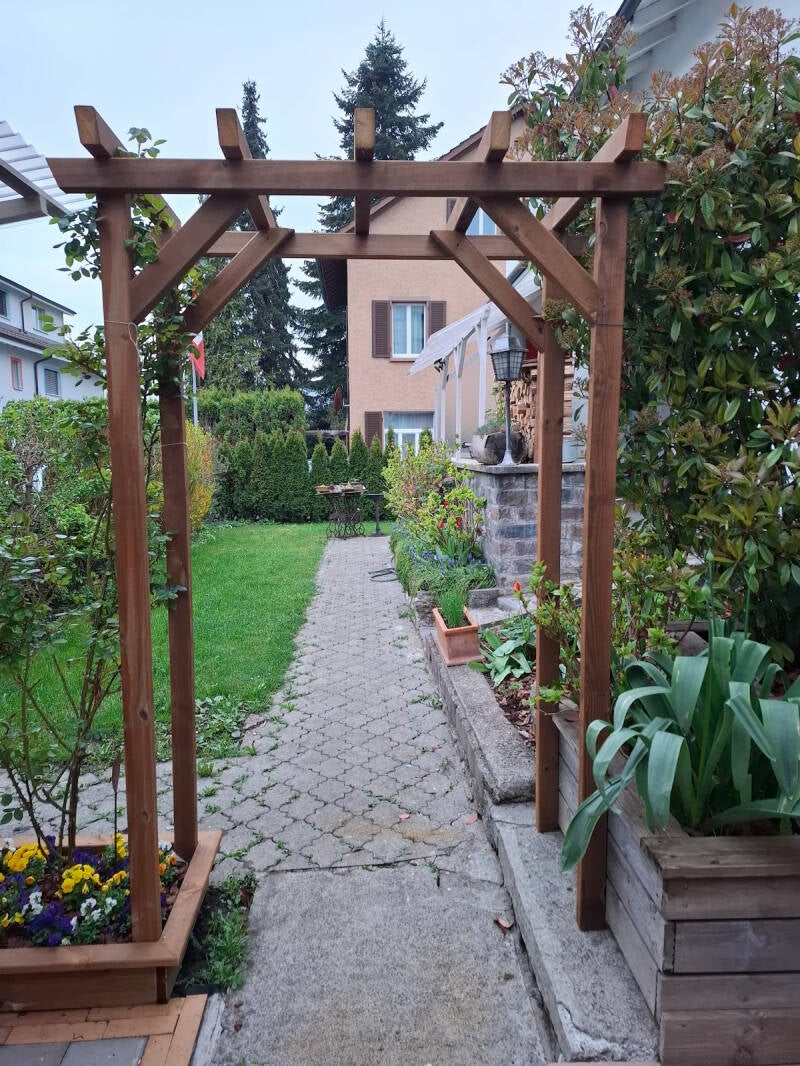 Individuell gefertigter Rosenbogen aus imprägniertem Holz als Rankhilfe im Garten.