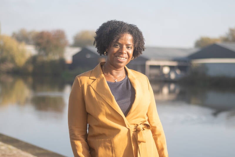 Portretfoto van Soraida Dammers, Register Jobcoach tegen de achtergrond van het Deventer Havenkwartier