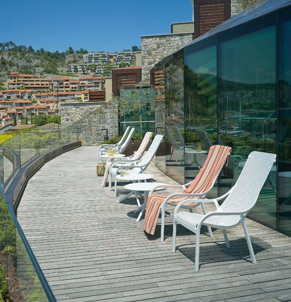 Fauteuils Nardi Net Lounge sur une terrasse en bois avec vue