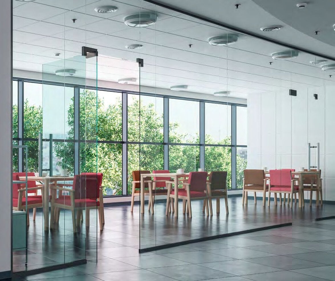 Grande salle de restaurant lumineuse d'EHPAD avec tables et chaises colorées