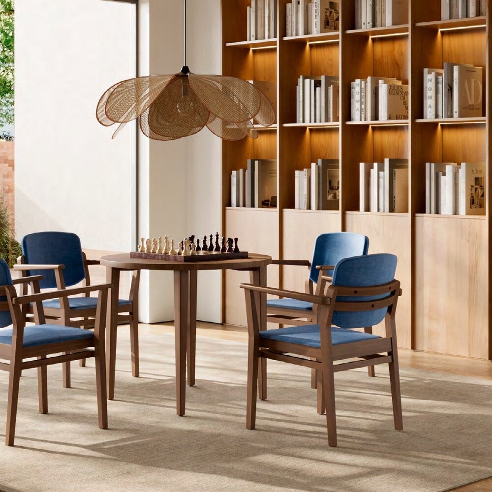 Salon bibliothèque de résidence senior avec chaises en bois Fenabel, mobilier haut de gamme pour EHPAD