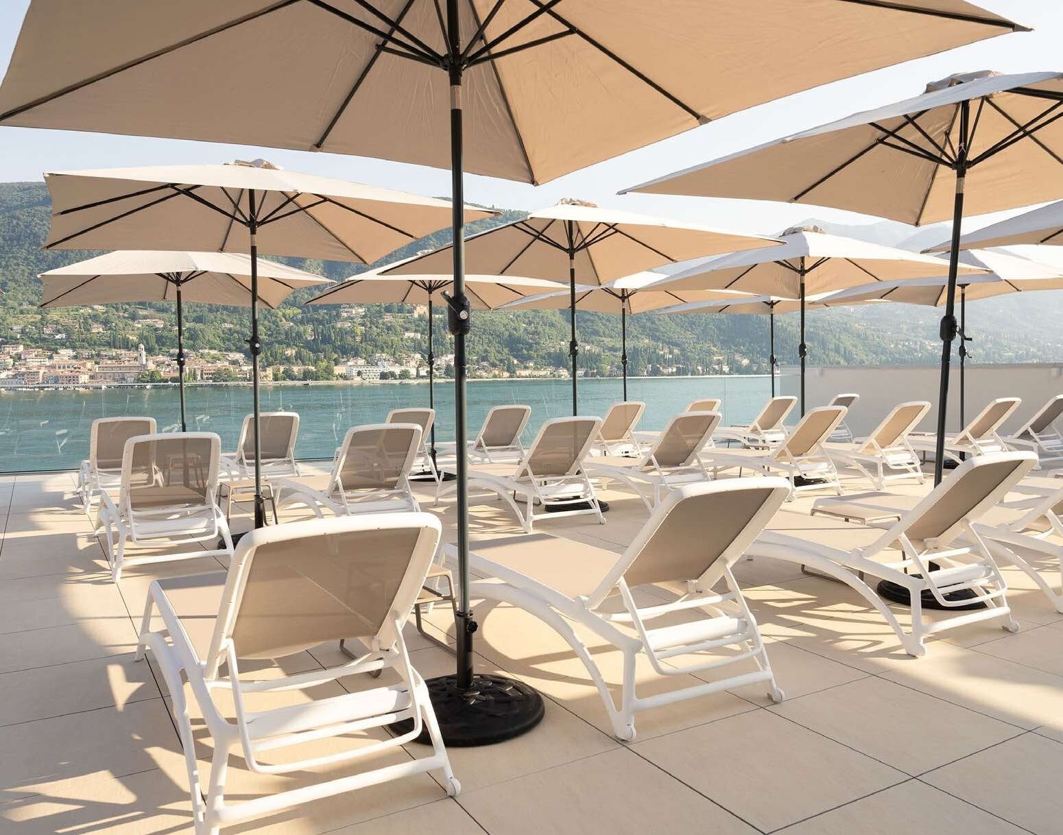 Transats Nardi Atlantico sous parasols sur la terrasse d'un hôtel en bord de lac