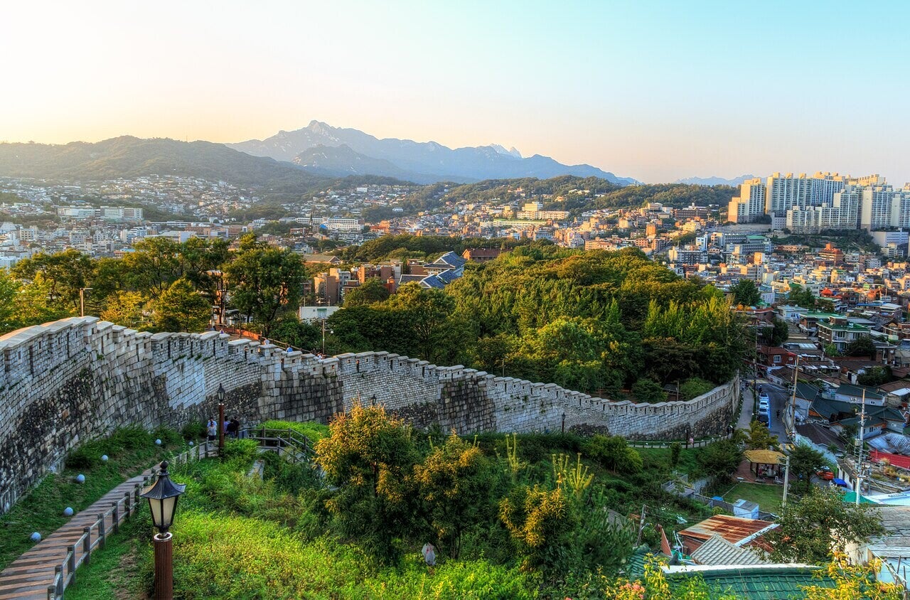 De historische stadsmuur van Hanyangdoseong op een berghelling, met Seoul op de achtergrond