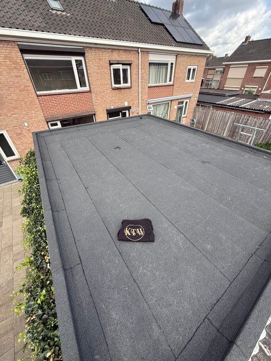 Dakdekker van KTW aan het werk op een plat dak