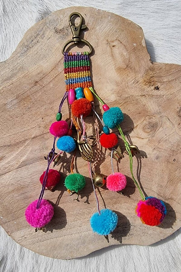 Handgemaakte hanger met kleurrijke pompoms en roze kraal