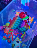 A picture of brightly coloured sensory toys and fidget toys in a clear plastic box