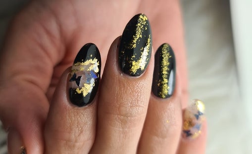 Acrylnagels zwart met gouden nailart in amandelvorm