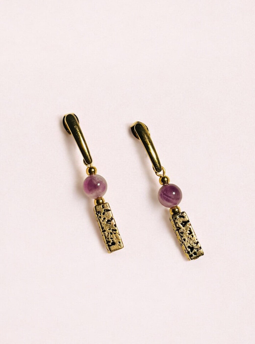 Goudkleurige oorbellen met lava steen en amethist