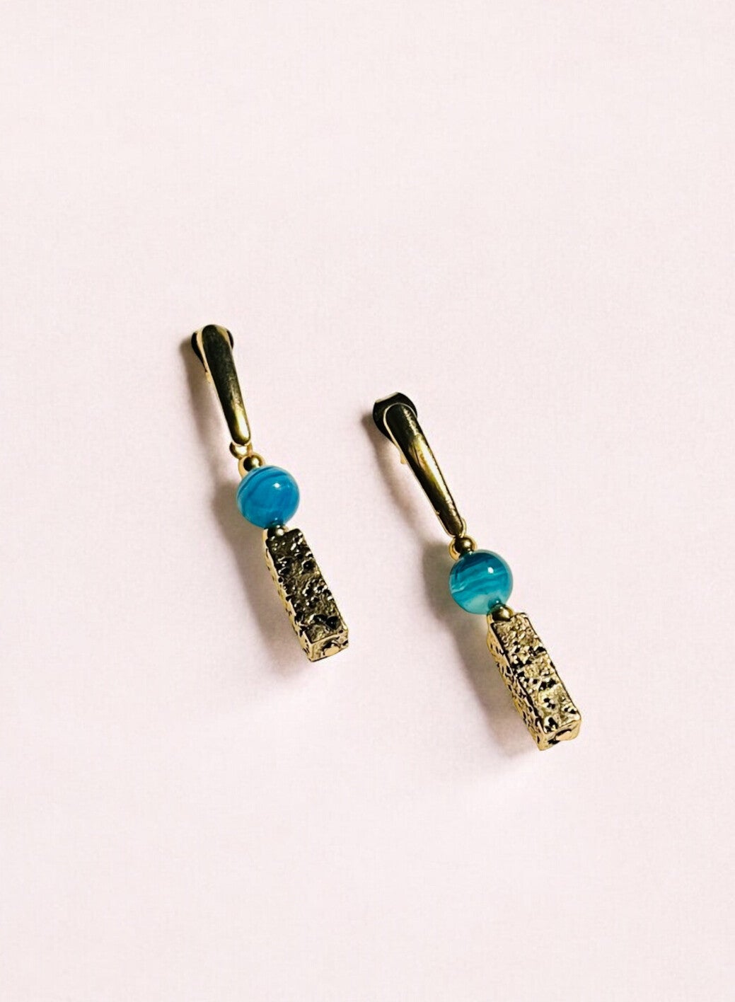 Goudkleurige oorbellen met lava steen en blauw gestreepte jasper