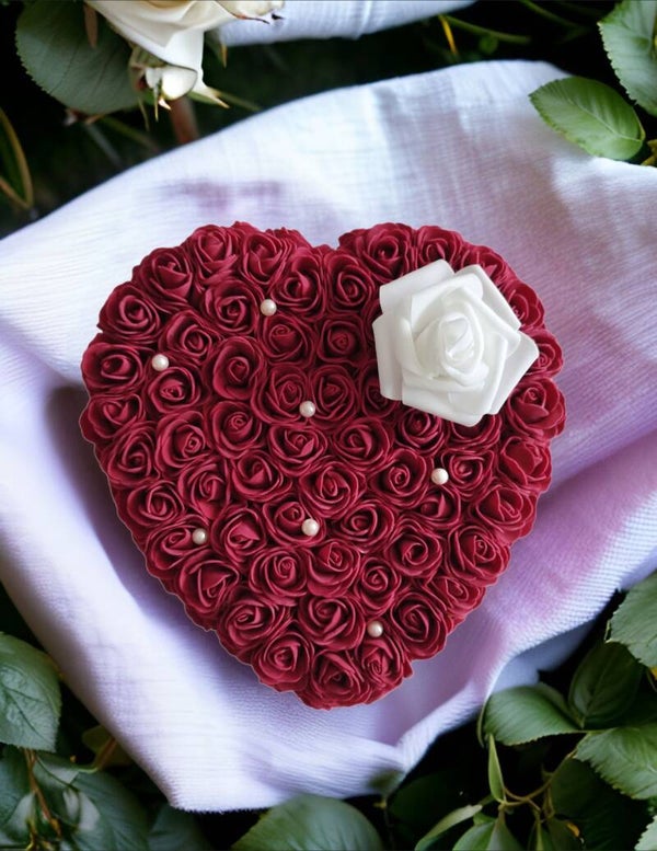 coussin en cœur bordeau et une fleure blanche