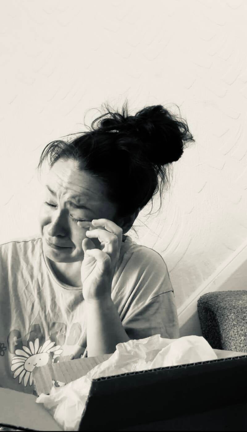 Happy customer moved to tears unboxing a TTRS Crystals package with personalized guided message card in Wigan