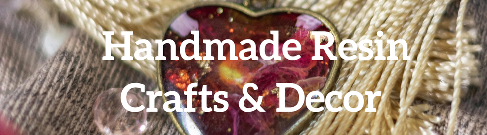 A delicate resin heart surrounded by colorful yarn and shimmering glass beads.