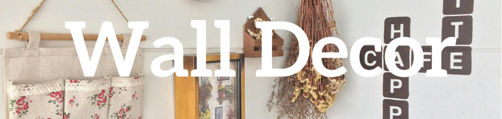 A stylish wall décor arrangement featuring decorative letters, lush plants, a rustic wood frame, and cloth pockets for added texture.