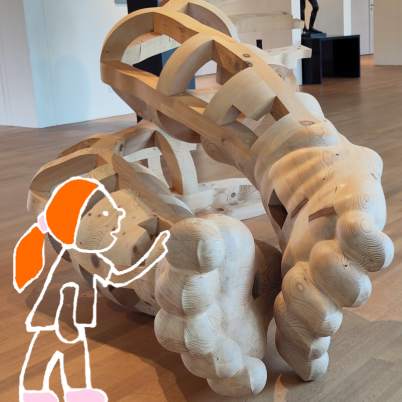 een houten beeld en een meisje