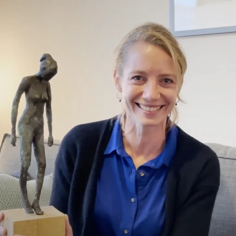 Portretfoto van Gea die lacheend een beeld vasthoudt