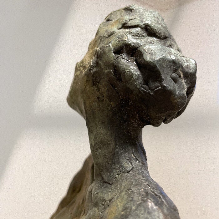Close-up van de achterkant van het hoofd en hals van een bronzen beeld van een vrouw
