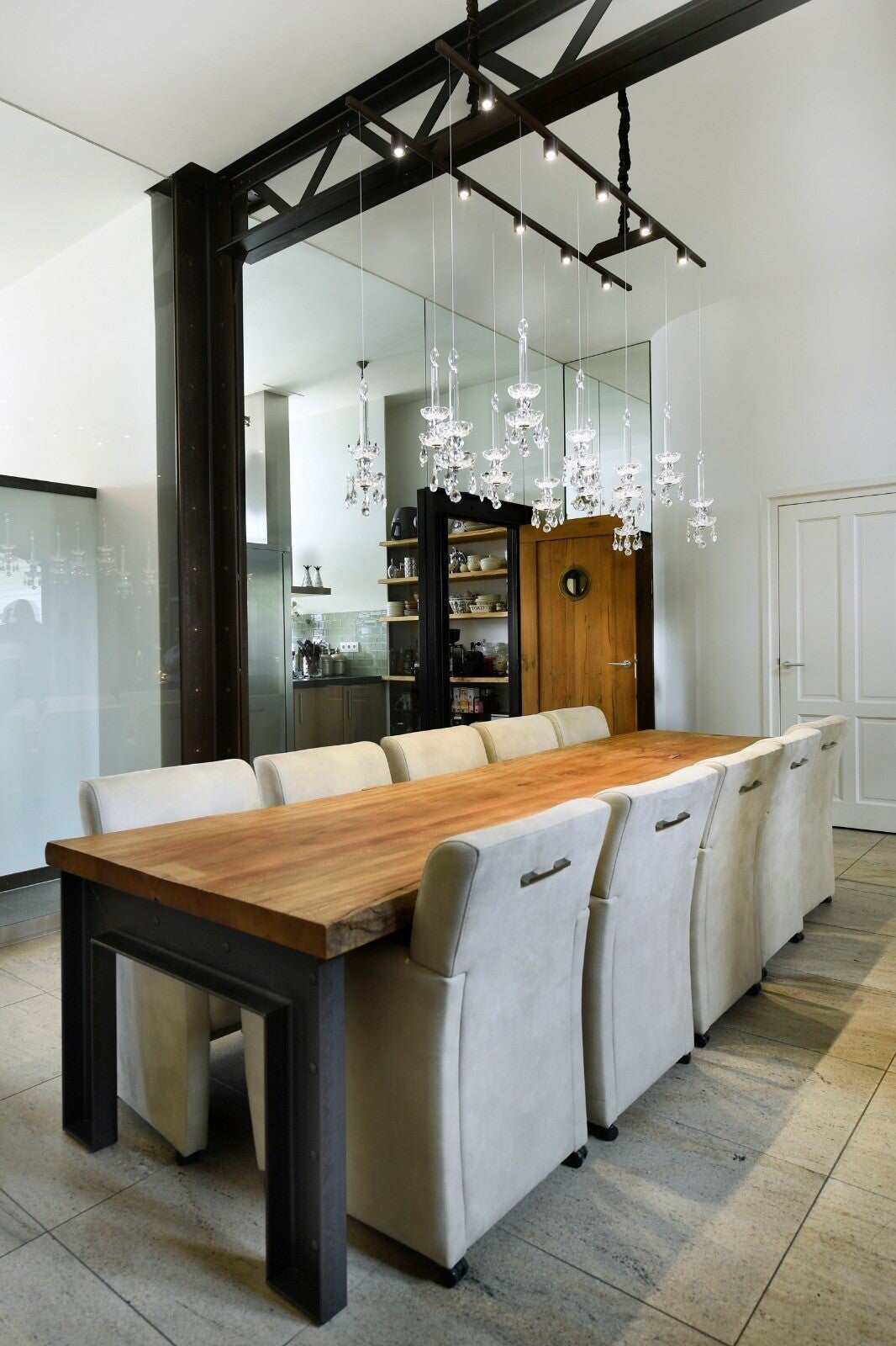 Floating Crystal chandeliers in dining area with glass wall – exclusive custom lighting by Groenensteyn Light.