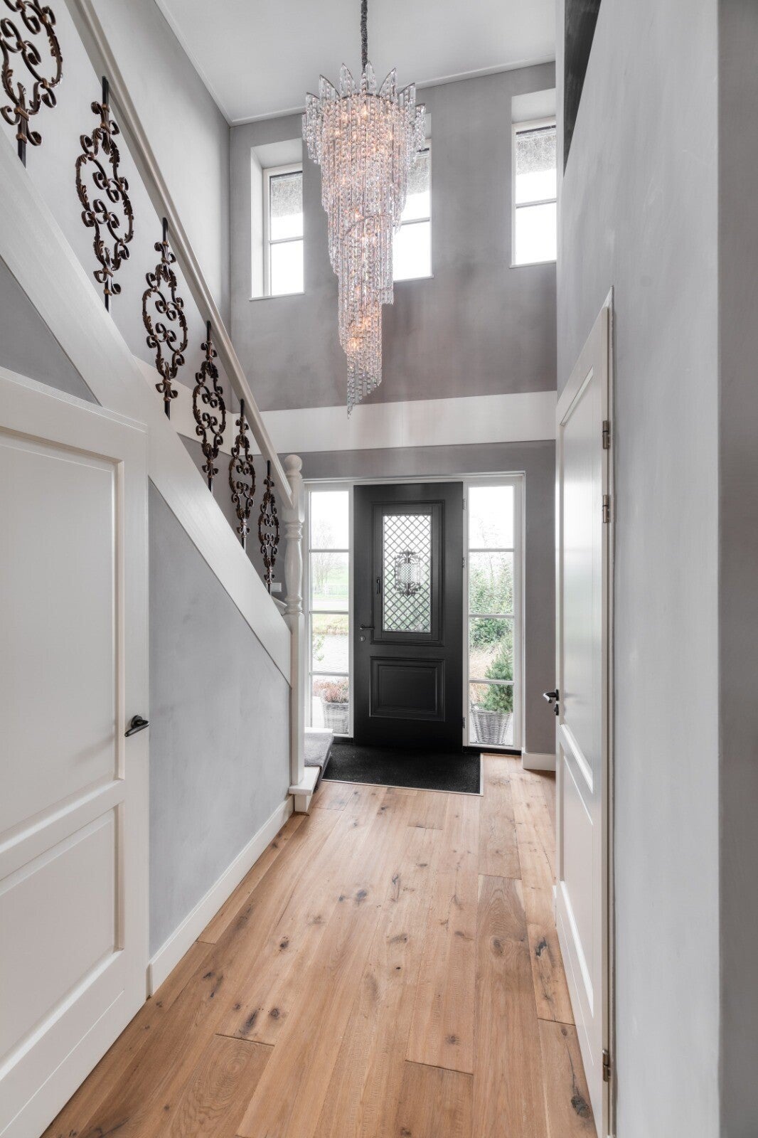Large crystal chandelier in luxury staircase hallway – custom-made chandelier by Groenensteyn Light.m