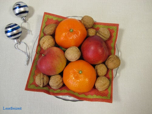 Ein bunter Weihnachtsteller mit Mandarinen, Äpfeln und Nüssen.