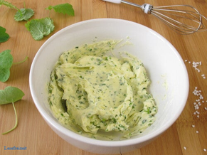 Selbst gemachte Kräuterbutter aus frischer Sahne und Kräutern in einer Schüssel.