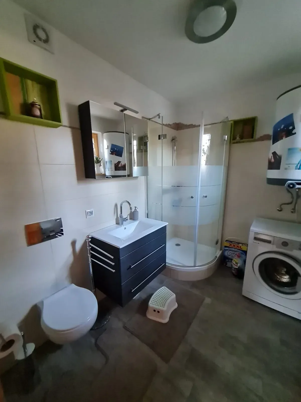 Modernes Badezimmer im Ferienhaus Hengsttal mit Dusche, Waschbecken, WC und Waschmaschine für Gäste.