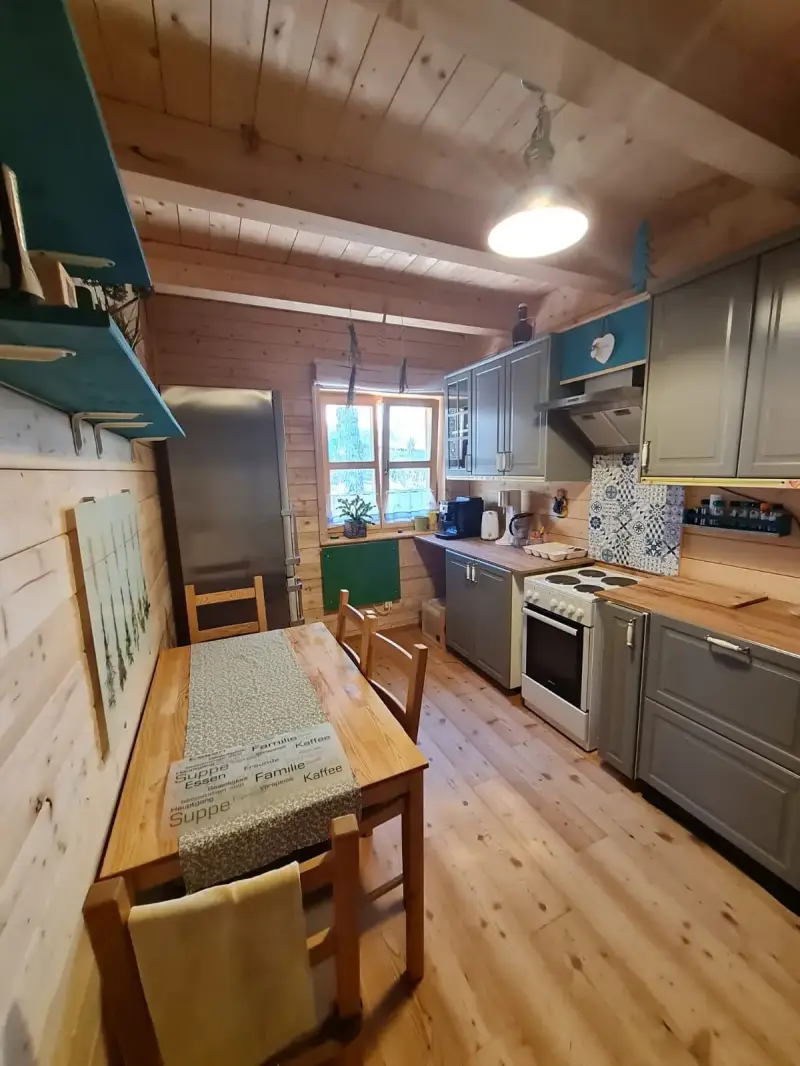 Voll ausgestattete Landhausküche im Blockhaus Hengsttal mit modernen Geräten, Kaffeemaschine und großem Kühlschrank.