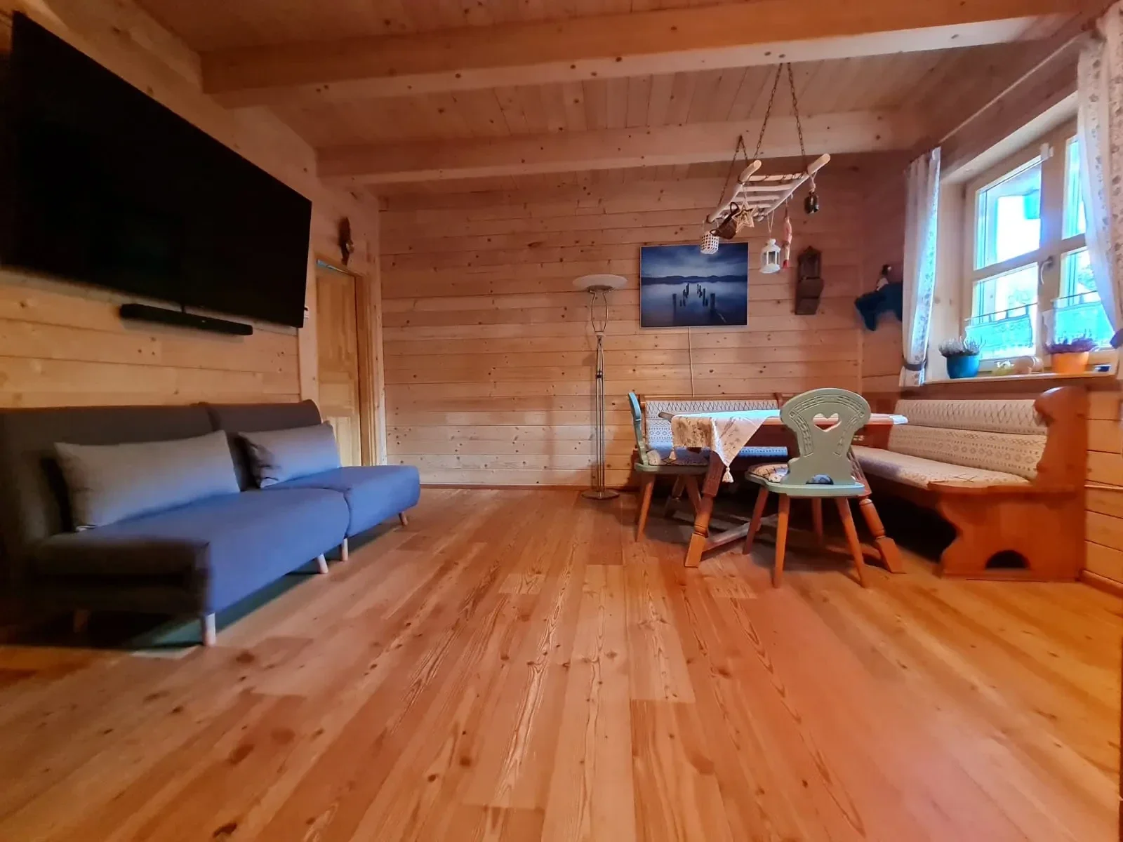 Gemütlicher Wohn- und Essbereich im Blockhaus Hengsttal mit Eckbank, Holztisch und moderner Couch.