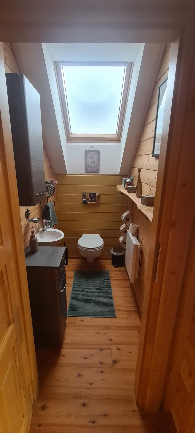 Separates, helles WC im Obergeschoss des Blockhaus Hengsttal mit Dachfenster, gemütlicher Holzausstattung und Blick in die Natur.