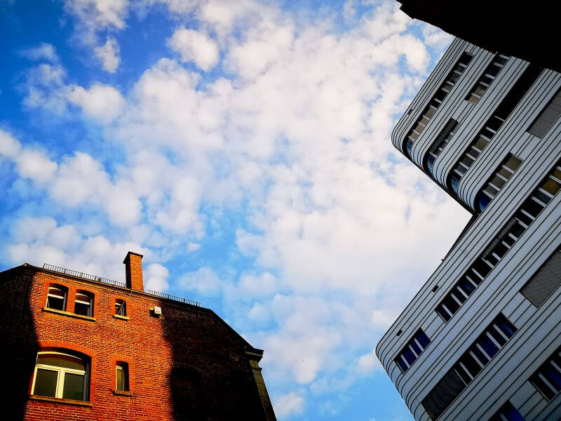 Aluminium et brique sous un ciel de moutons