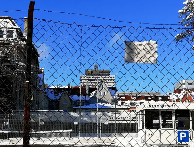 Wintersonne &amp; Schnee. Architekturfragmente hinter Maschendratzaun. 