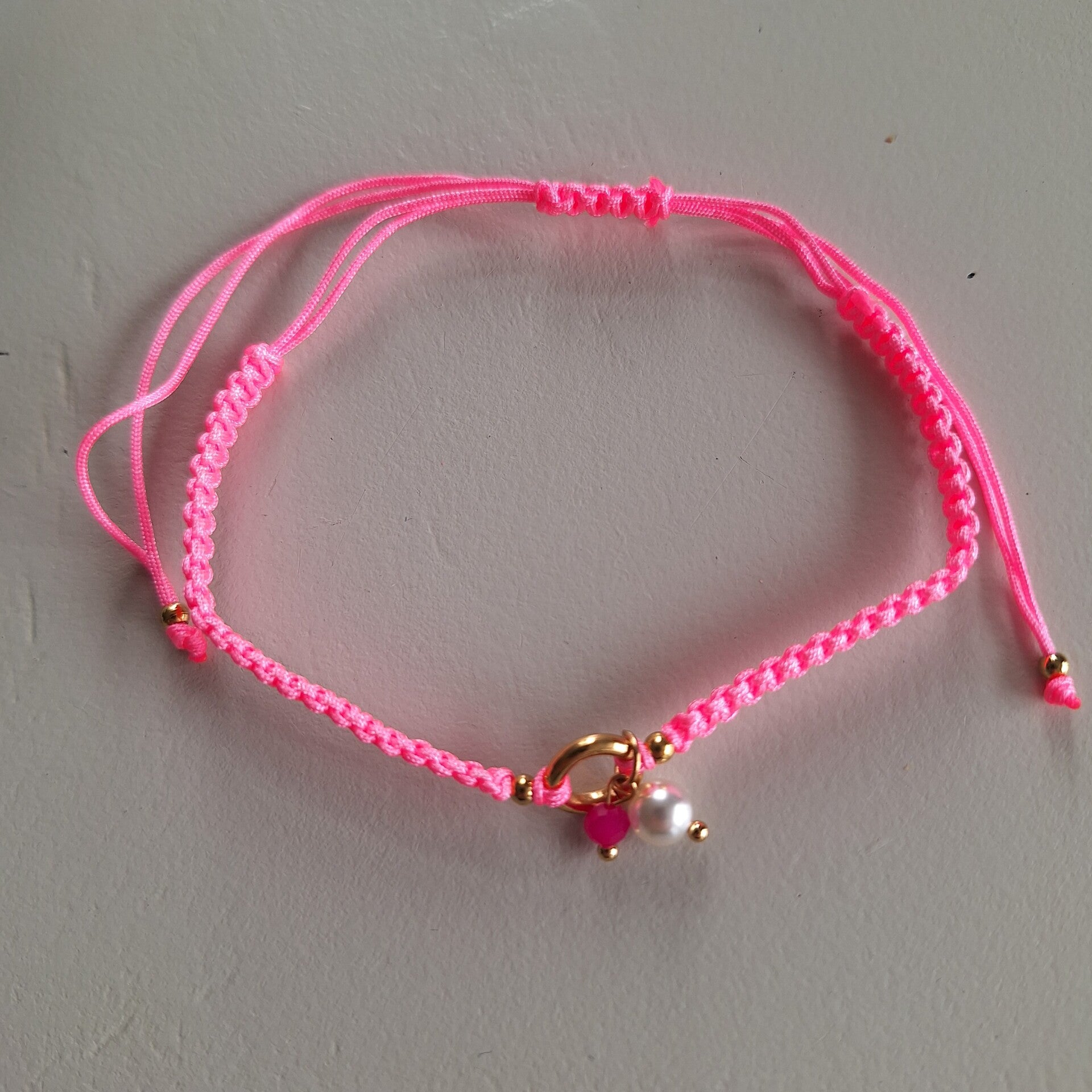 Roze gevlochten enkelbandje