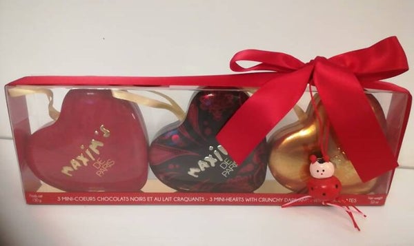 Drie metalen hartjes gevuld met dragee hartjes